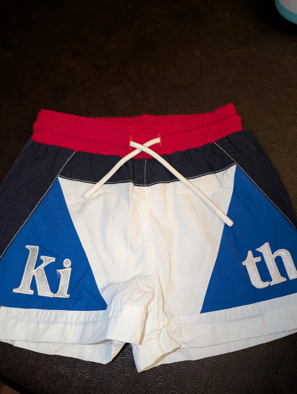 KITH Kids colorblock swim trunks in red, blue, & white w/ embroidered KITH logo